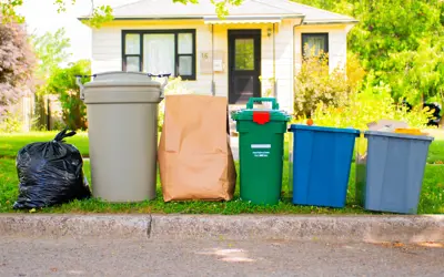 Garbage, organics and recycling set out curbside in front of a house