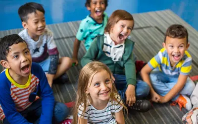 Smiling kids sitting on the floor in a child care setting