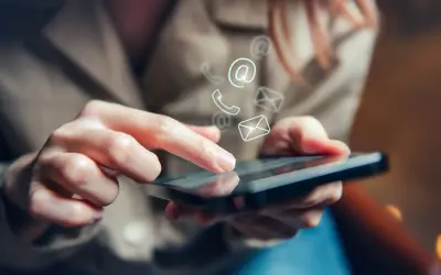 Hand on a cell phone with icons showing ways to contact such as phone, mail and email