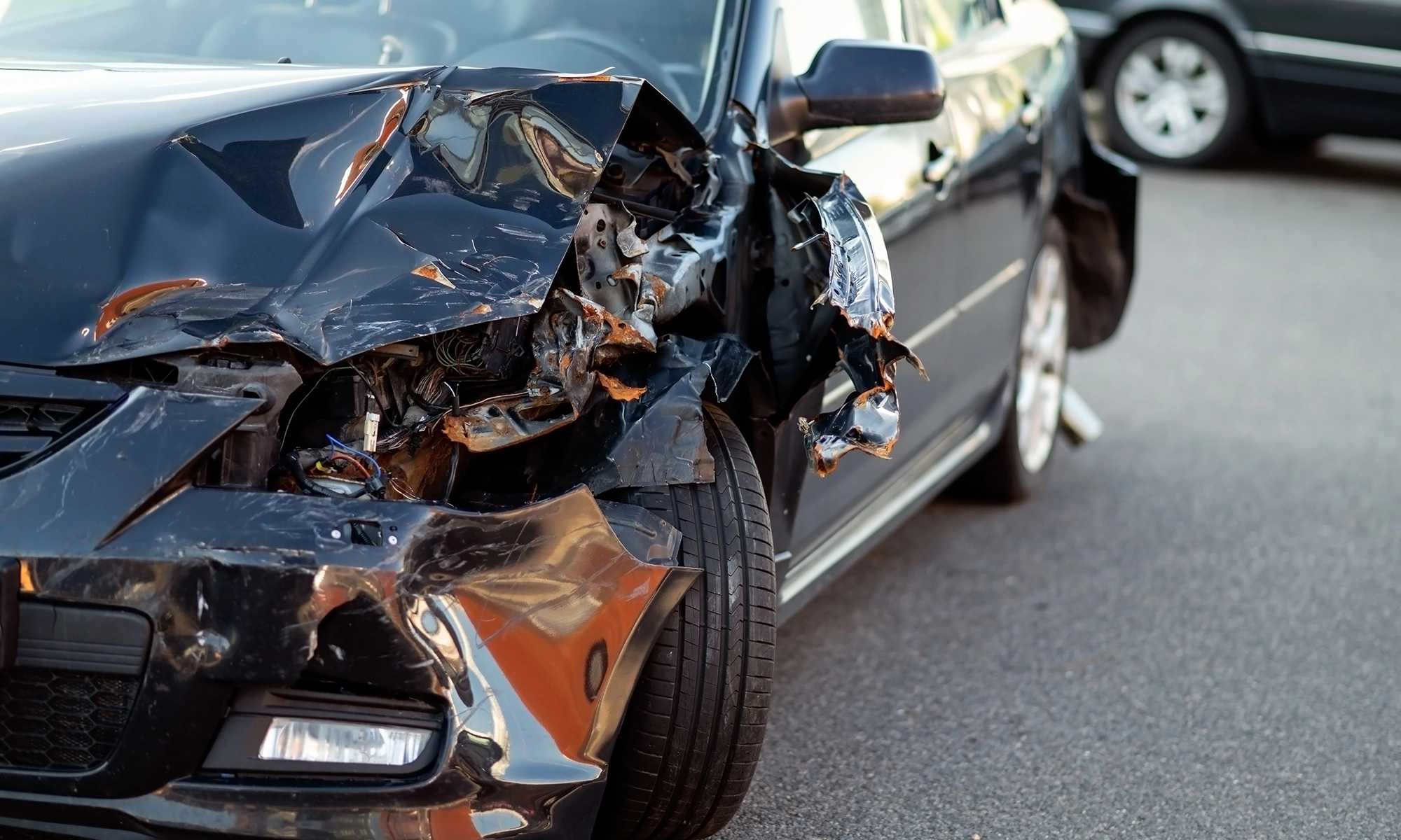 Closeup of front of car that has been damaged in a collision.