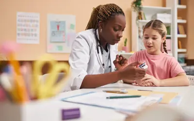 Nurse sitting with a student at a table in a school setting